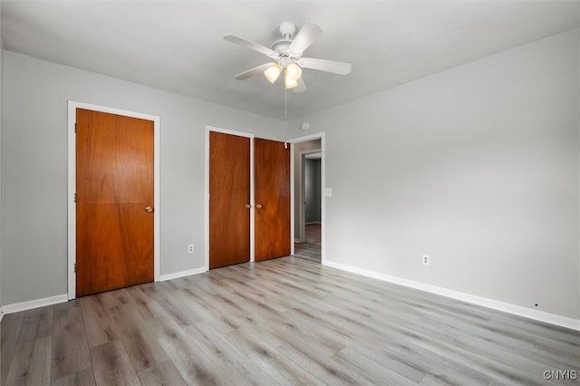 unfurnished bedroom featuring ceiling fan, a closet, wood finished floors, and baseboards