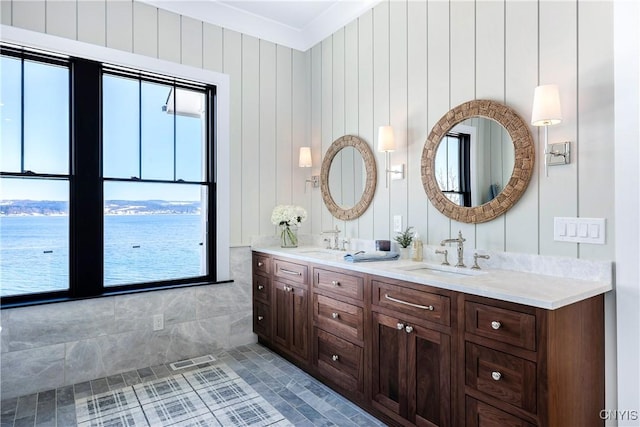 bathroom featuring crown molding, visible vents, a sink, and double vanity