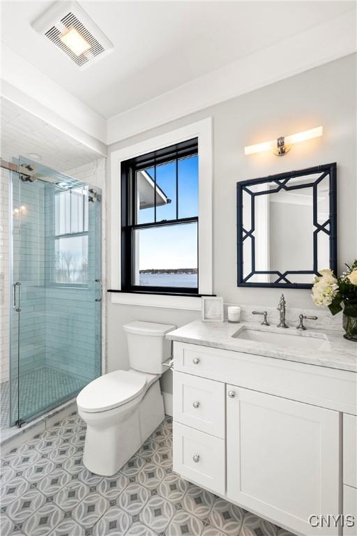 full bathroom featuring visible vents, toilet, a shower stall, vanity, and tile patterned floors