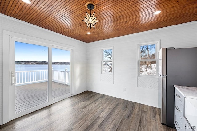 unfurnished dining area featuring dark wood-style flooring, a water view, and wooden ceiling