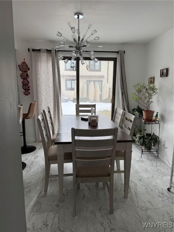 dining space featuring marble finish floor and an inviting chandelier