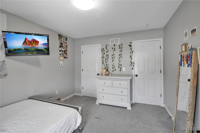 carpeted bedroom featuring visible vents and baseboards