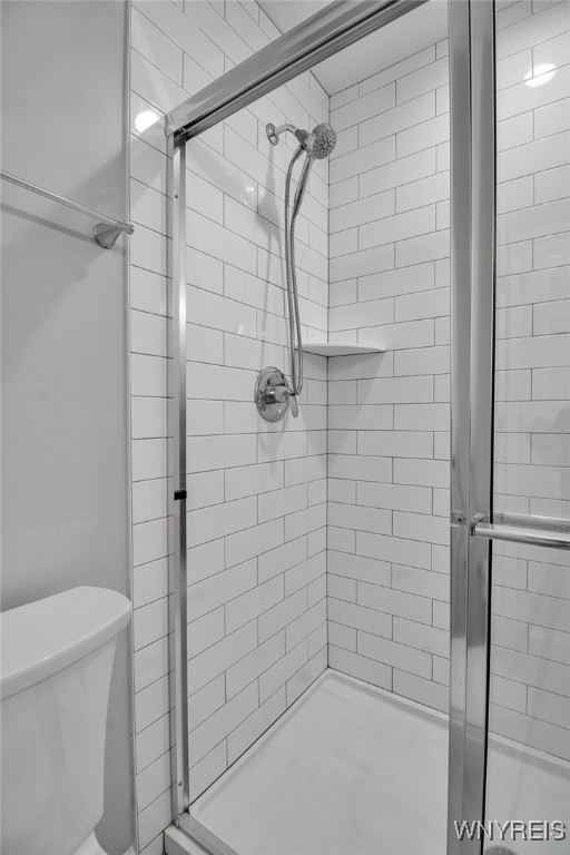 full bathroom with a stall shower and toilet