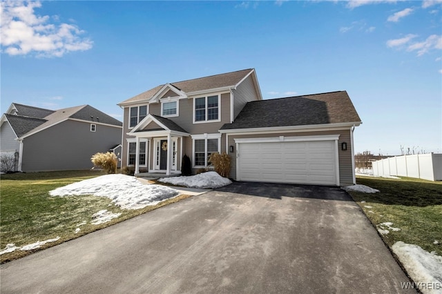 view of front of house with aphalt driveway, a front lawn, and a garage