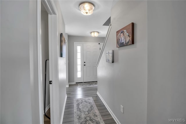 doorway with dark wood finished floors and baseboards