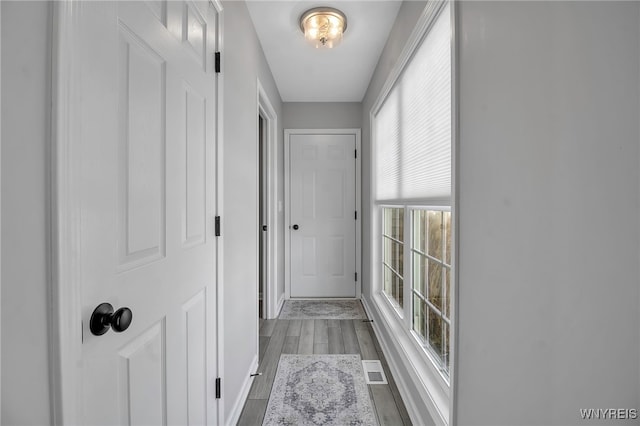 hallway featuring visible vents and wood finished floors