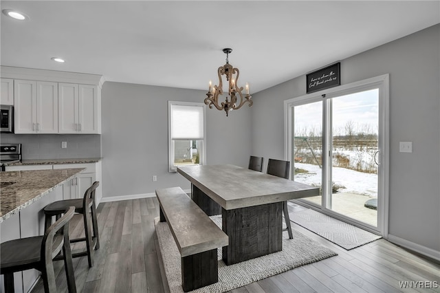 dining space with baseboards, a chandelier, wood finished floors, and recessed lighting