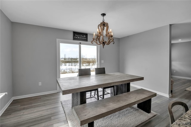 dining area with a notable chandelier, baseboards, and wood finished floors