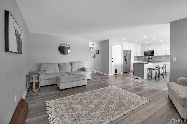 living area with dark wood-style floors, recessed lighting, and baseboards