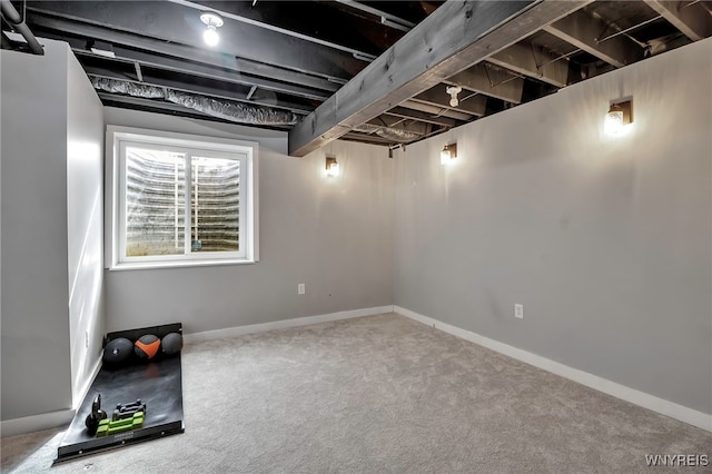 below grade area featuring carpet flooring and baseboards