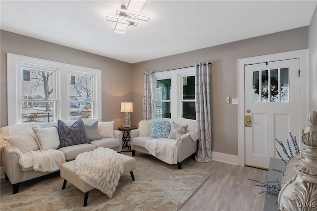 living area featuring light wood-style floors, a wealth of natural light, and baseboards