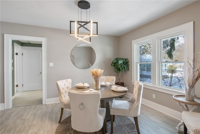 dining area featuring baseboards, a chandelier, and light wood-style floors