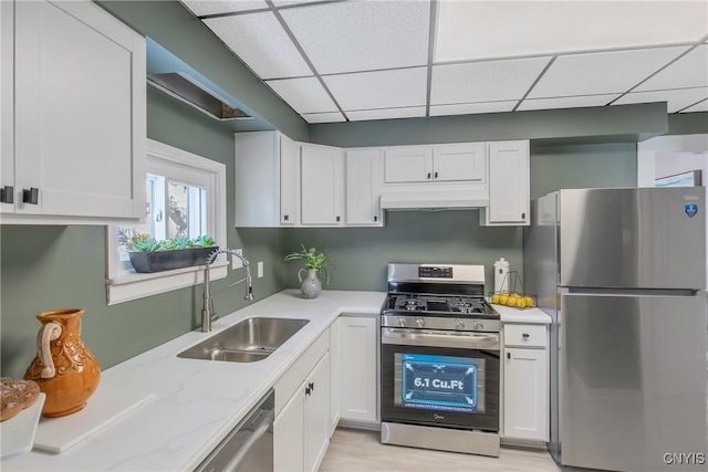 kitchen featuring white cabinets, under cabinet range hood, stainless steel appliances, and a sink