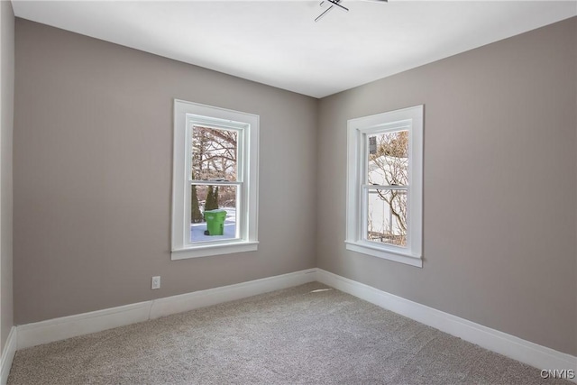 carpeted spare room with a wealth of natural light and baseboards