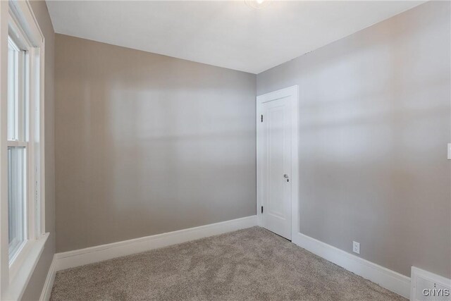 carpeted empty room with visible vents and baseboards