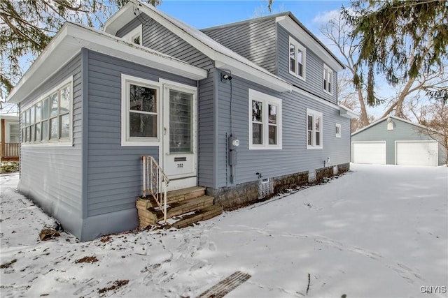 bungalow-style home featuring entry steps, an outdoor structure, and a detached garage