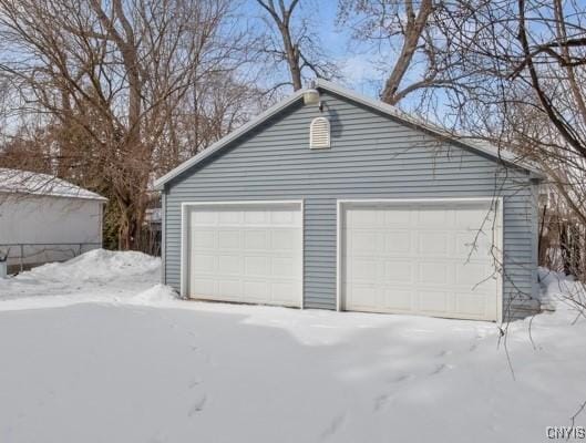 snow covered garage featuring a garage