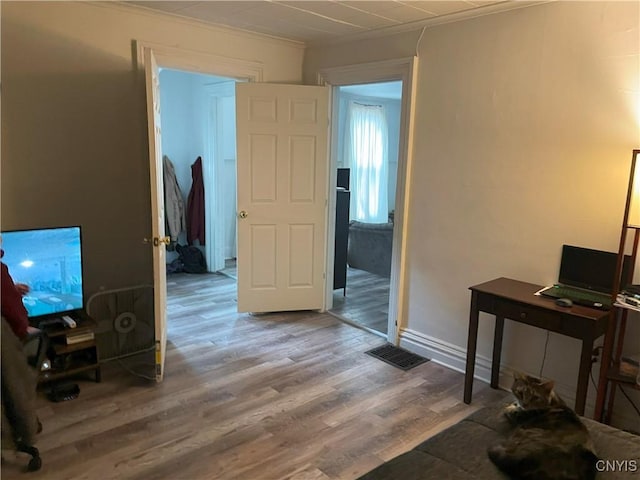 office area featuring ornamental molding, visible vents, baseboards, and wood finished floors