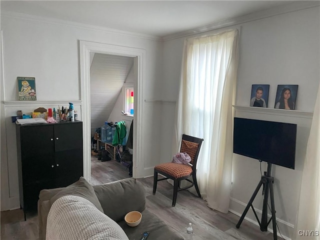 sitting room featuring baseboards, ornamental molding, and wood finished floors