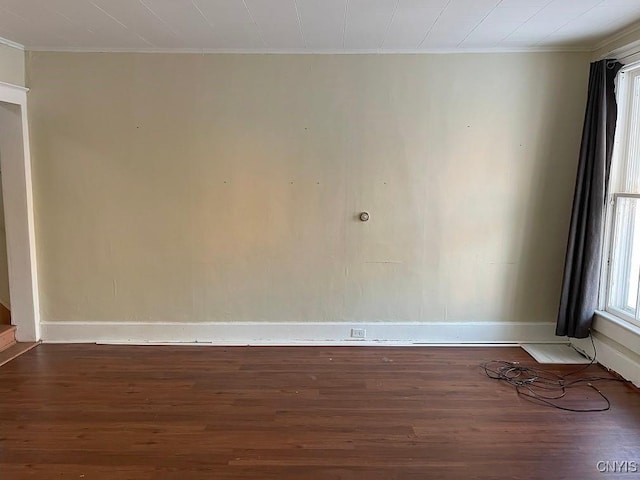 unfurnished room featuring ornamental molding, stairway, wood finished floors, and baseboards