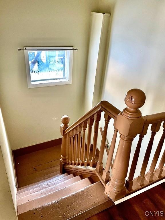 stairway with baseboards and wood finished floors