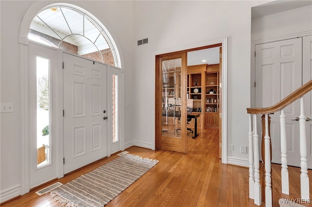 entryway featuring stairway, light wood-type flooring, and visible vents