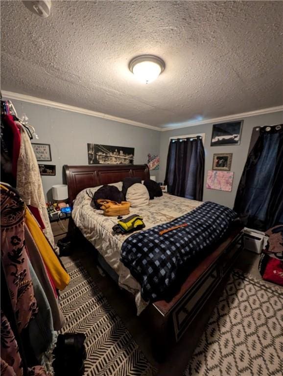 bedroom with a textured ceiling and crown molding