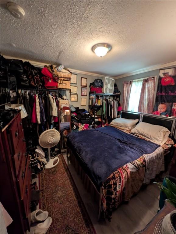 bedroom featuring a textured ceiling and crown molding