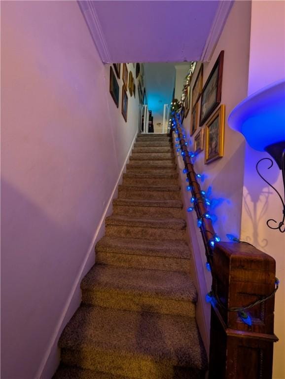 staircase with baseboards and crown molding