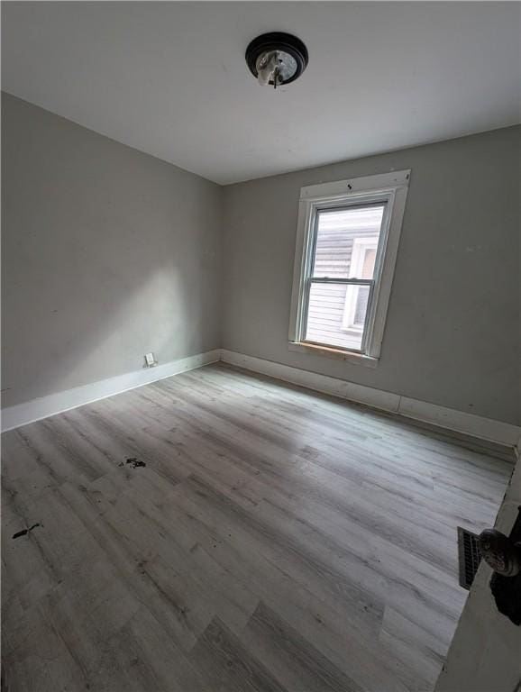 empty room with visible vents, baseboards, and wood finished floors