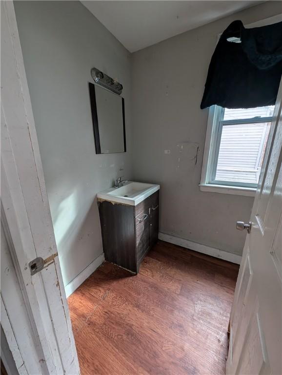 bathroom with wood finished floors, vanity, and baseboards