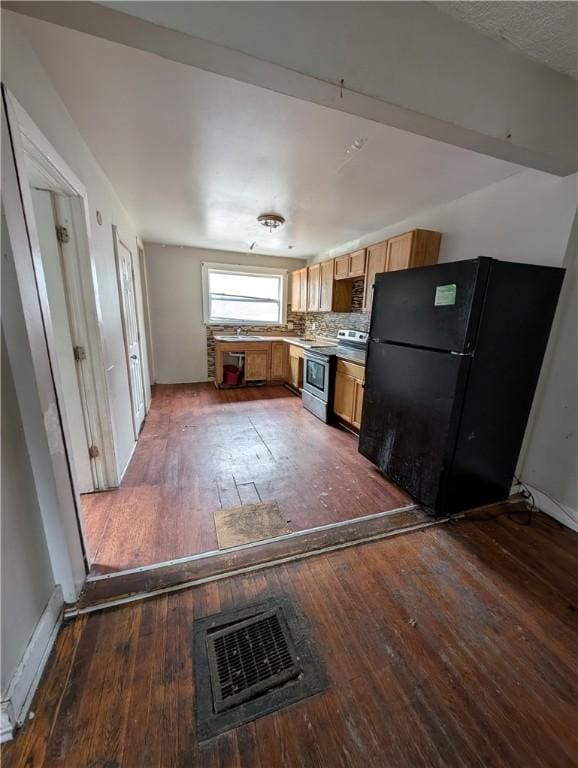 kitchen with visible vents, backsplash, freestanding refrigerator, stainless steel range with electric cooktop, and hardwood / wood-style flooring