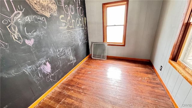 empty room featuring baseboards and hardwood / wood-style flooring