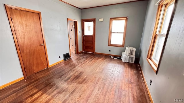 interior space with crown molding, baseboards, and wood finished floors