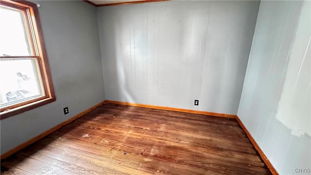 unfurnished room featuring a wealth of natural light, baseboards, and hardwood / wood-style floors