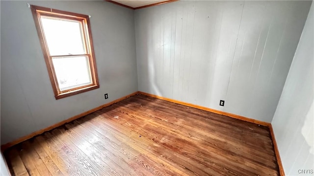 unfurnished room featuring hardwood / wood-style flooring and baseboards