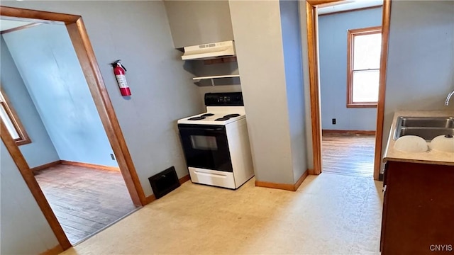 kitchen with baseboards, electric range, a sink, and under cabinet range hood