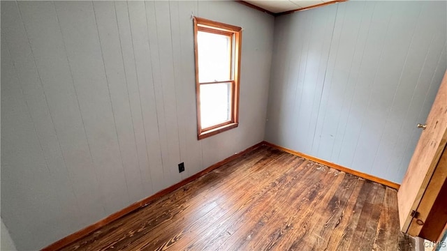 unfurnished room featuring hardwood / wood-style flooring and baseboards