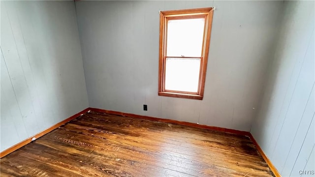 empty room featuring hardwood / wood-style flooring and baseboards