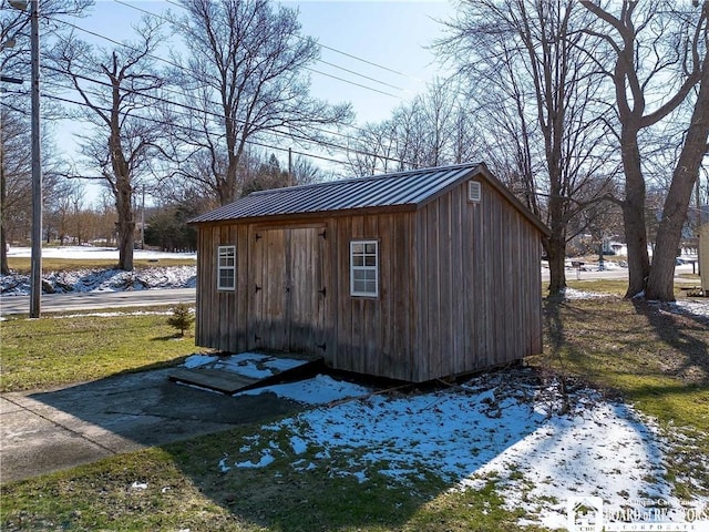 snow covered structure with an outbuilding and a shed