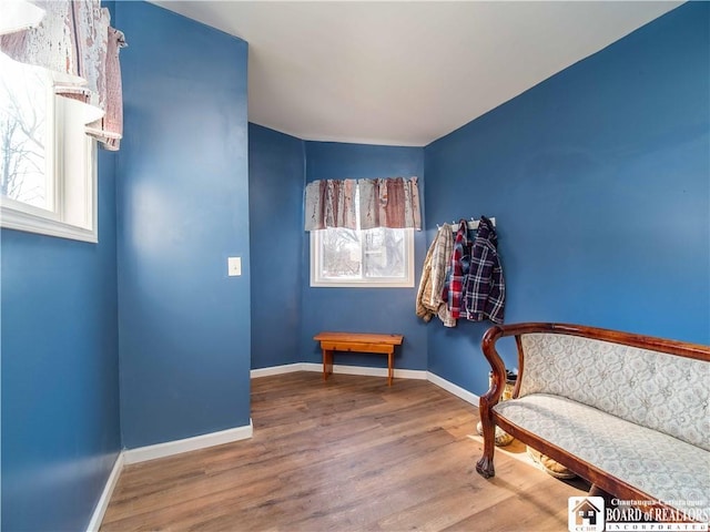 sitting room with baseboards and wood finished floors