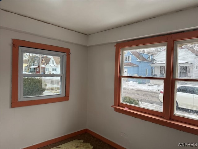 spare room with plenty of natural light and baseboards