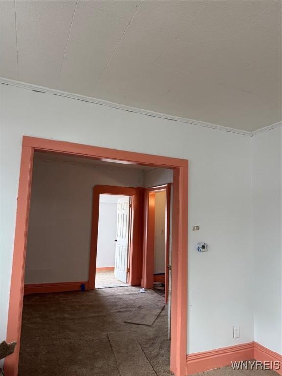 unfurnished room with carpet floors and baseboards