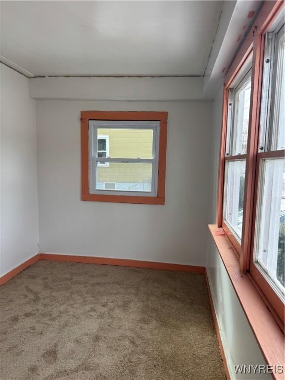 unfurnished room featuring carpet and baseboards