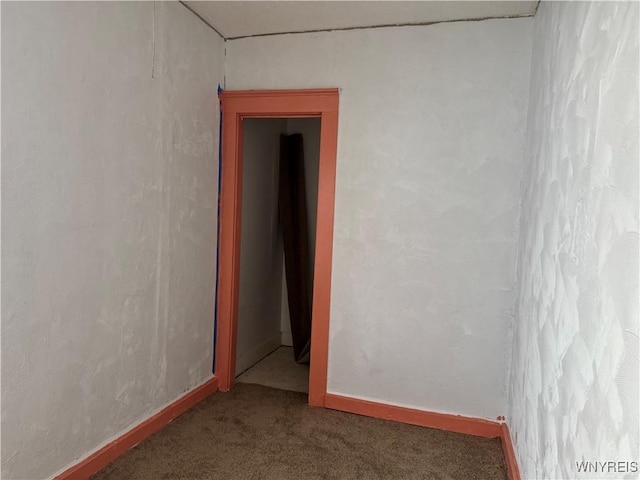 unfurnished room with baseboards and carpet flooring