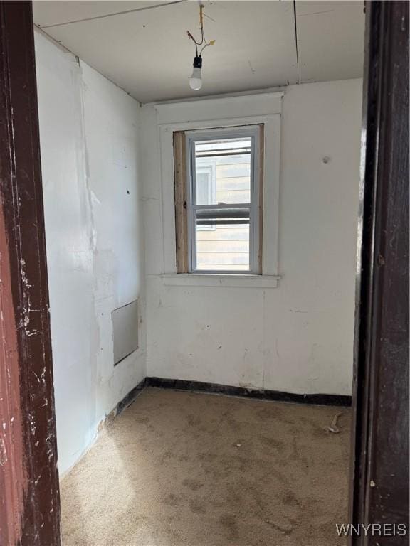 unfurnished room featuring carpet floors and baseboards