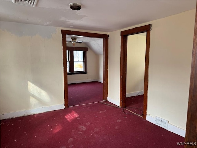 carpeted spare room with lofted ceiling, visible vents, and baseboards