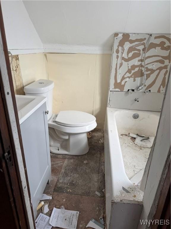 bathroom with toilet, a tub, and vanity