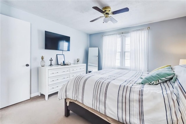 bedroom featuring ceiling fan, baseboards, and light colored carpet