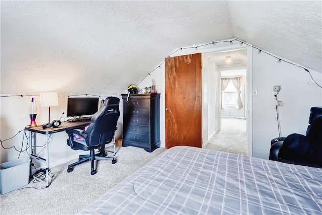 carpeted bedroom with vaulted ceiling and a textured ceiling